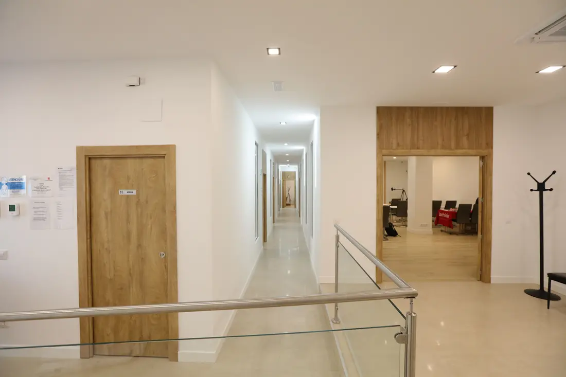 Pasillo de acceso a los gabinetes, con la barandilla de cristal
